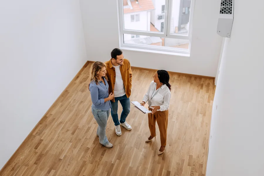 Real estate agent walking a couple through an empty home
